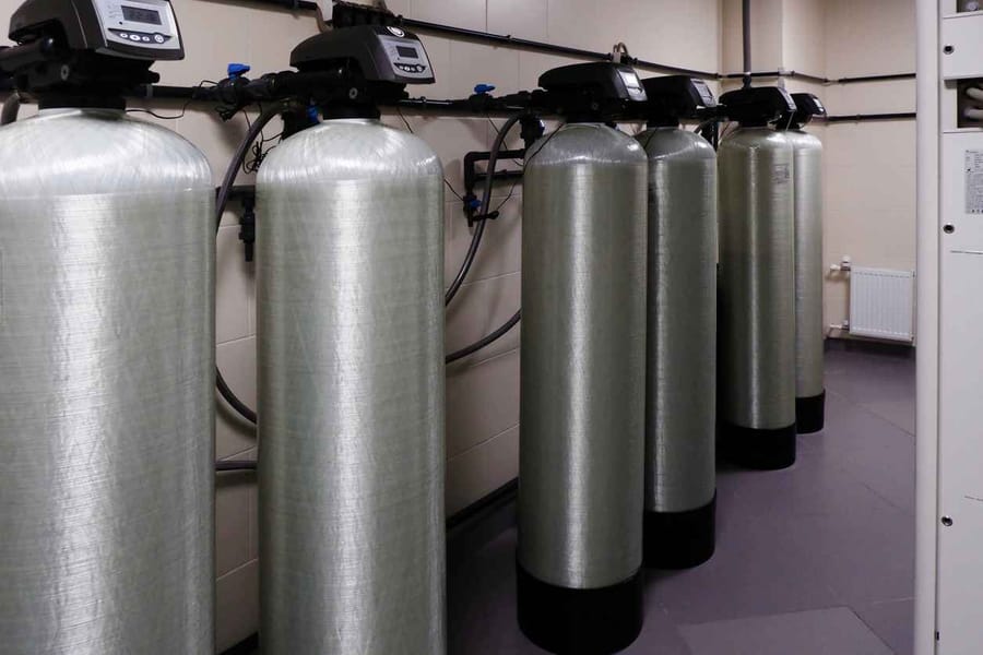 Several water softener filters standing in a row
